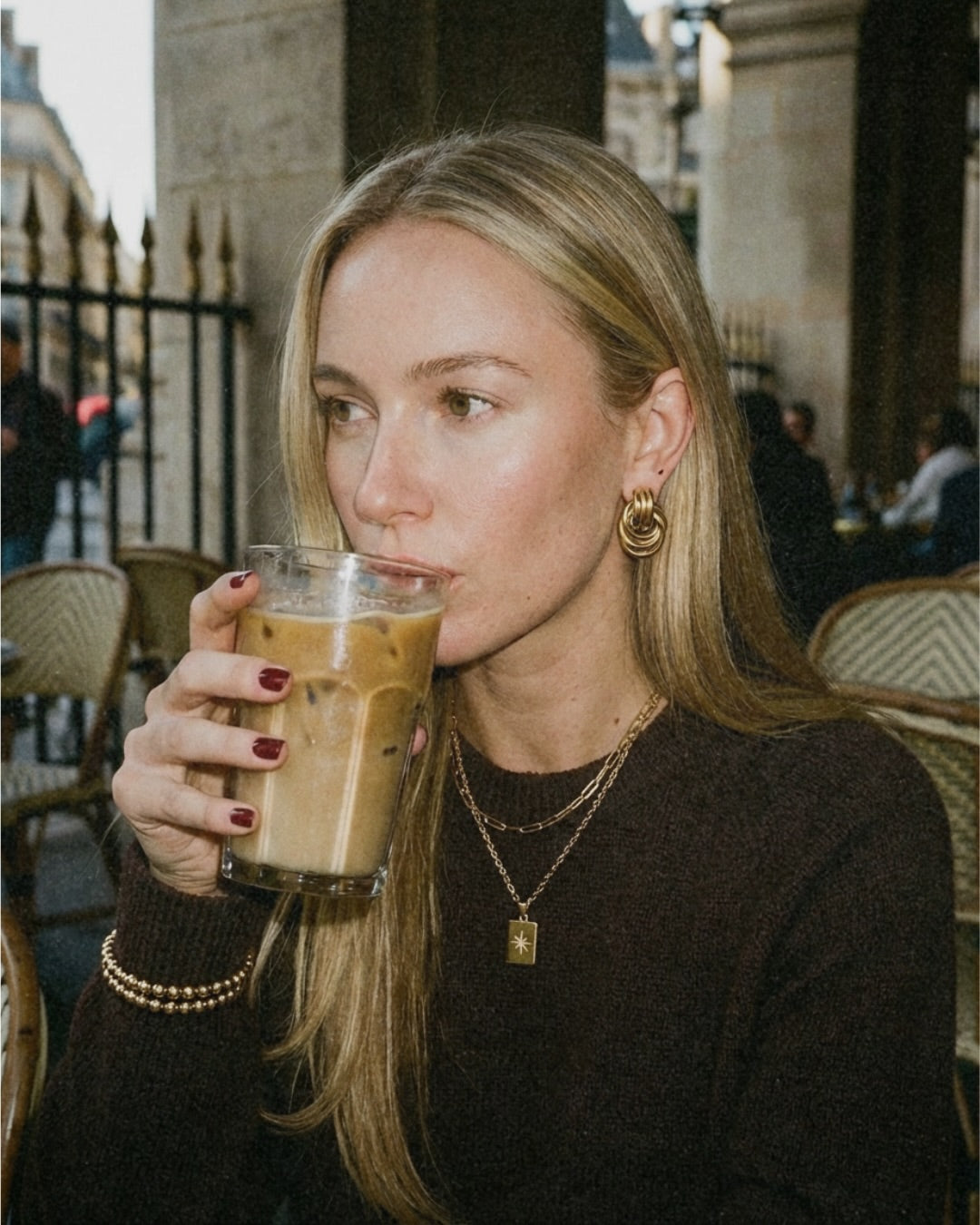 Knot earrings and a star tag necklace on a café terrace in the morning