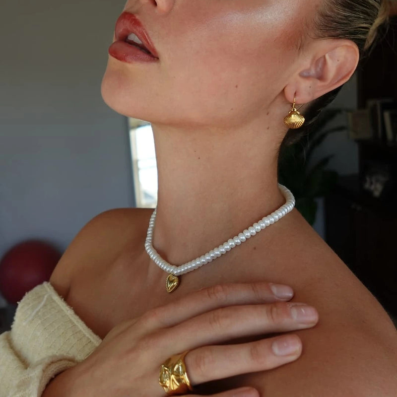 Close view of the pearl heart necklace and molten ring worn together
