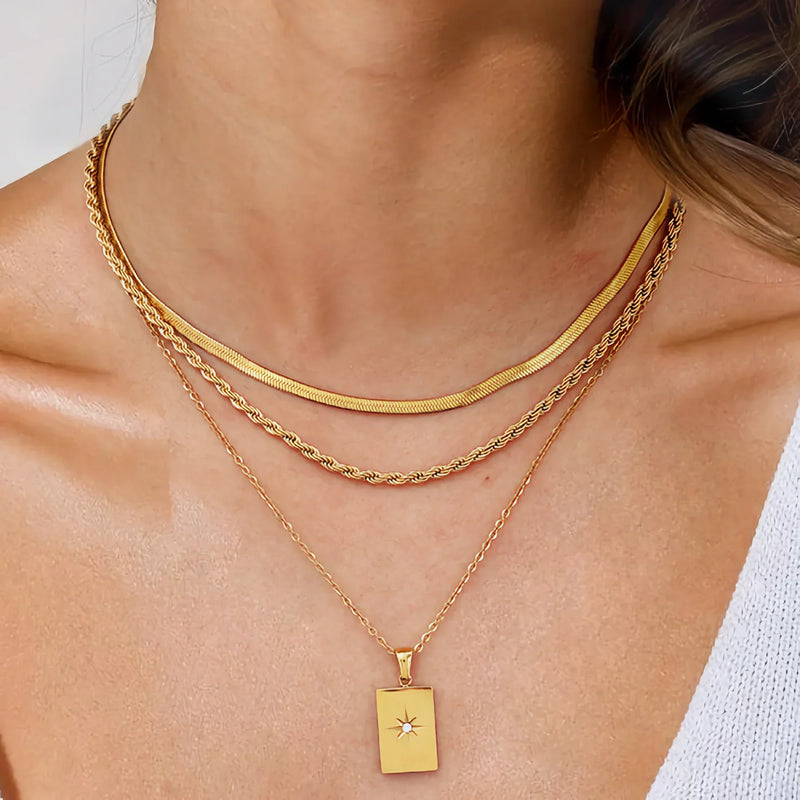 Close view of the star tag pendant on layered gold-tone chains