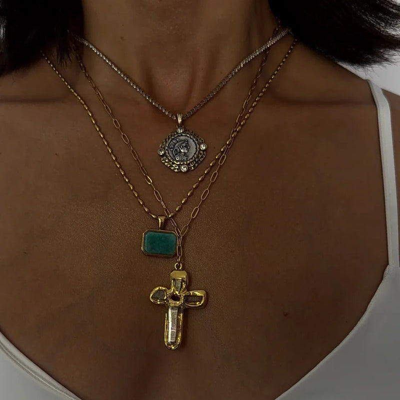 Green rectangular stone pendant worn with a cross and chains