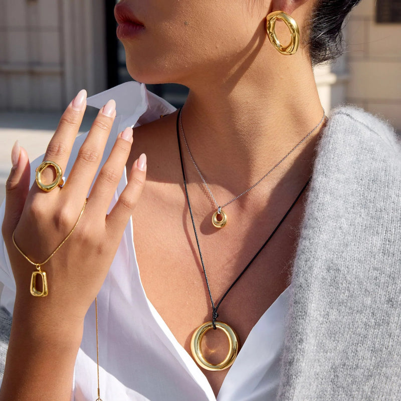 Halo ring pendant on a cord, worn with a matching earring