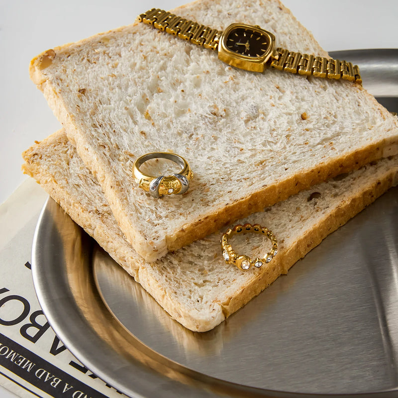 Two rings resting on slices of toast on a metal tray