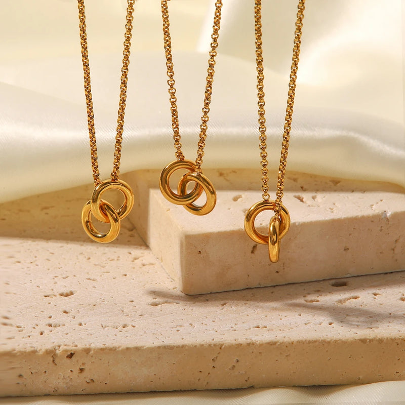 Three linked circles necklaces at different lengths on stone