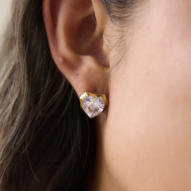 Matching heart crystal stud earring worn on an ear, close crop