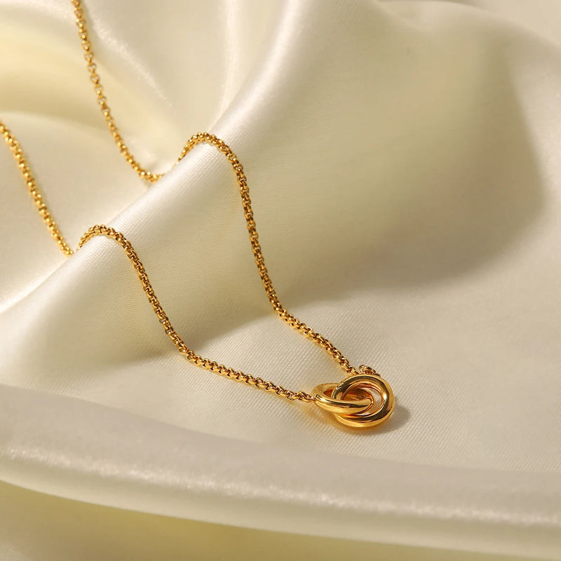 Linked circles pendant on a chain over cream satin