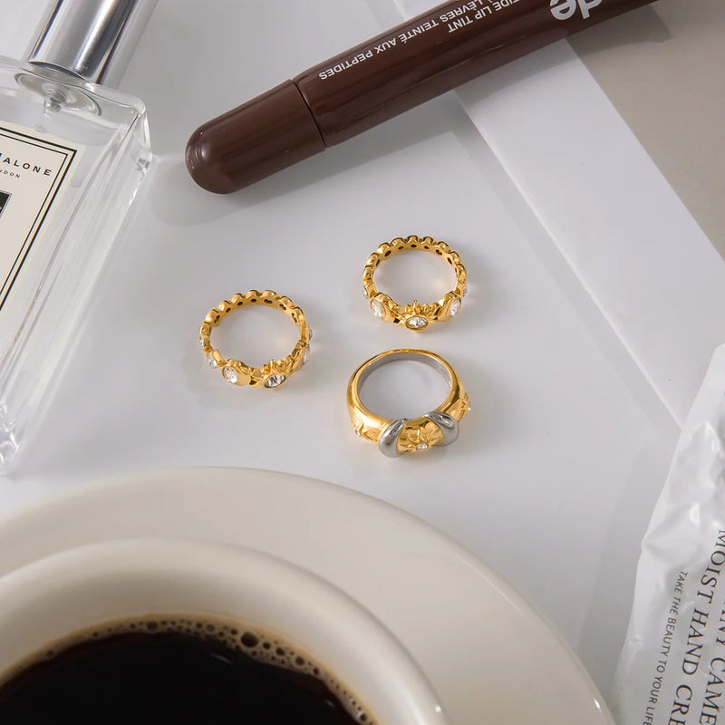 Two rings on a pale surface beside coffee and a lip product