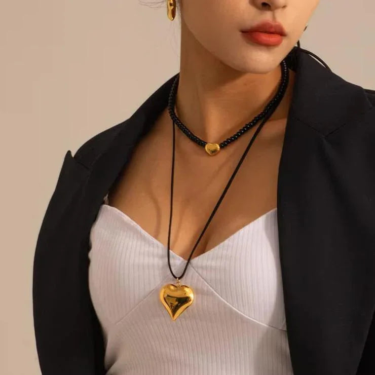 Heart cord necklace worn layered with a beaded choker