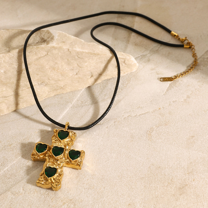 Cross pendant cord necklace laid flat on a pale surface