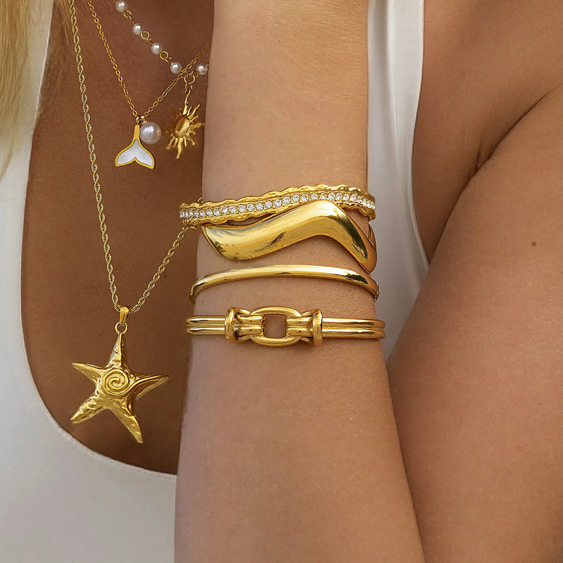 Layered starfish and pearl sun necklaces worn with stacked bangles