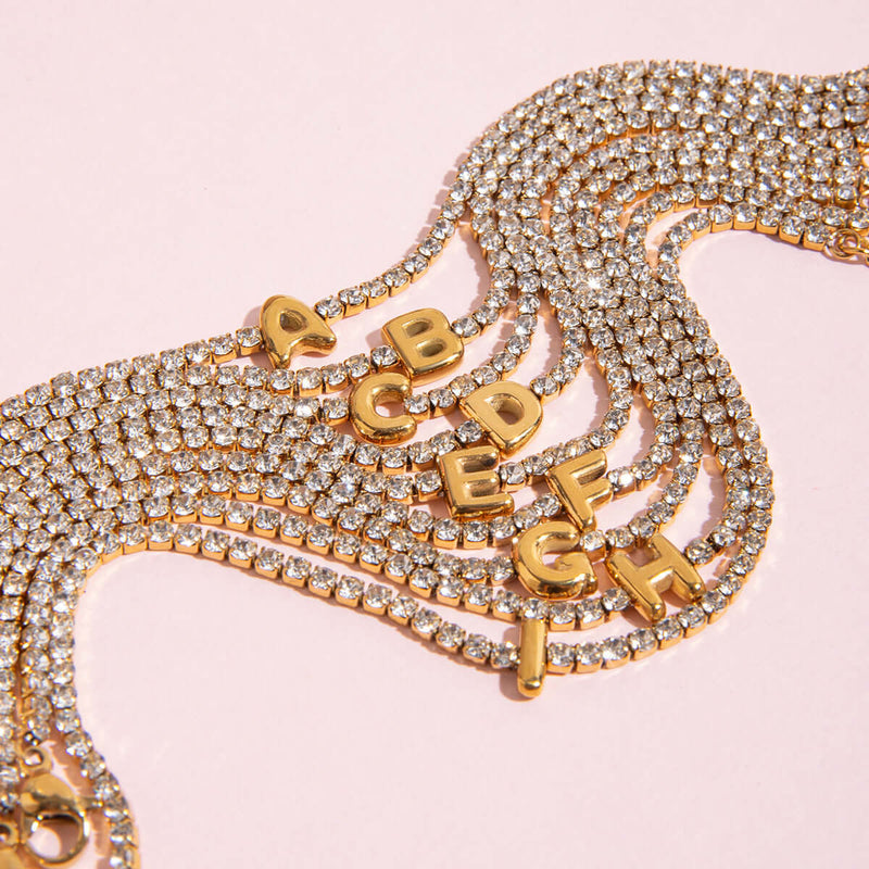 Pauline Initial Crystal Tennis Bracelet, a row of letters on a pink background