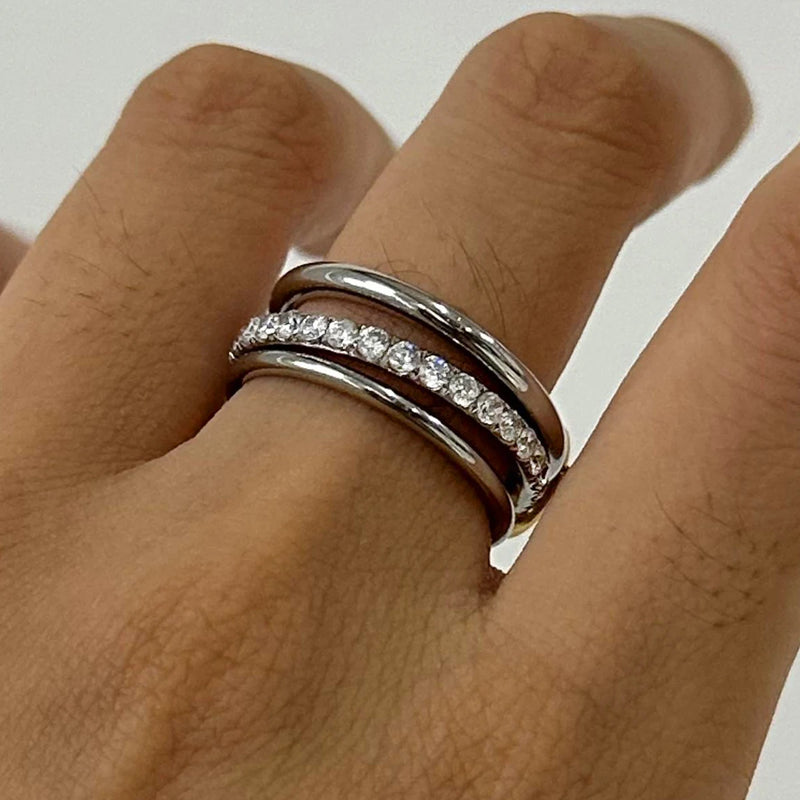 Close view of the interlocking crystal-set triple band on a finger