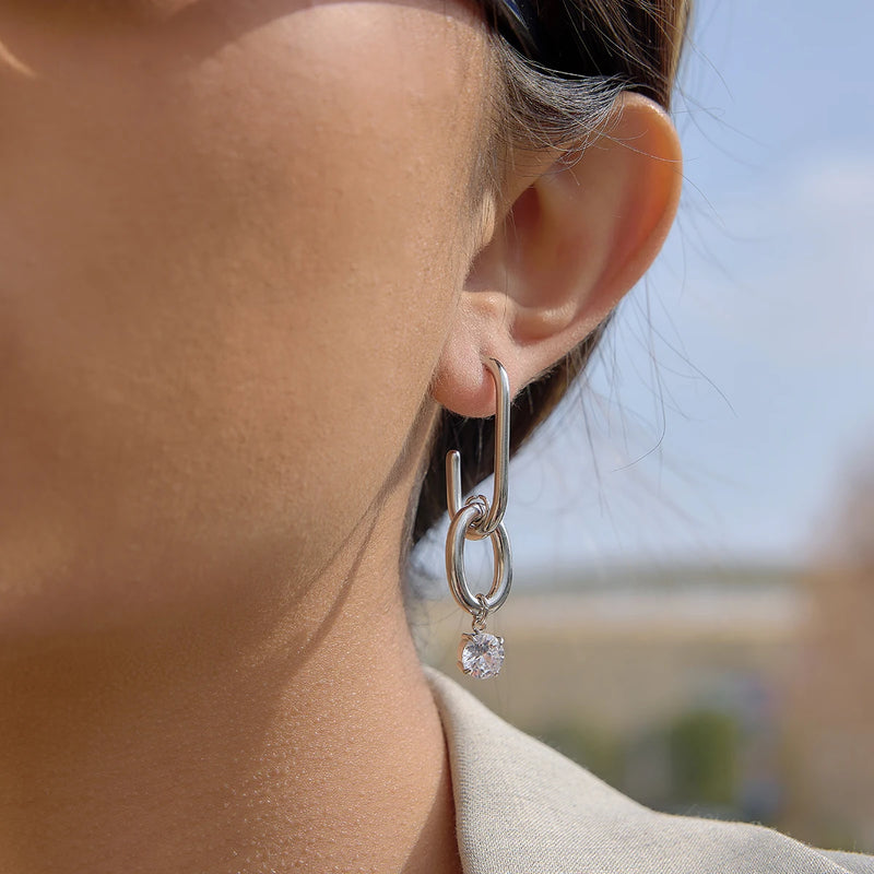 Silver-tone link drop earring worn on the lobe