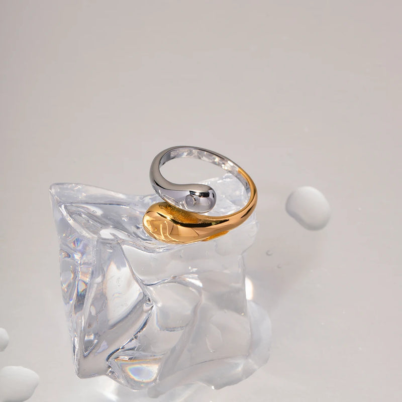 Two-tone open wrap ring resting on a clear glass form