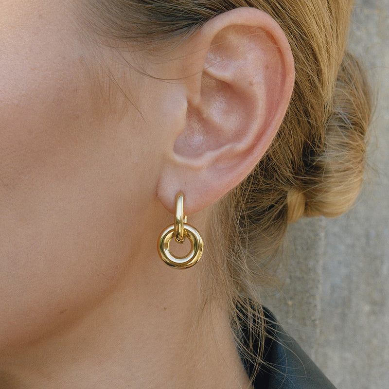 Maud Interlocking Ring Hoop Earrings worn on the ear in gold-tone