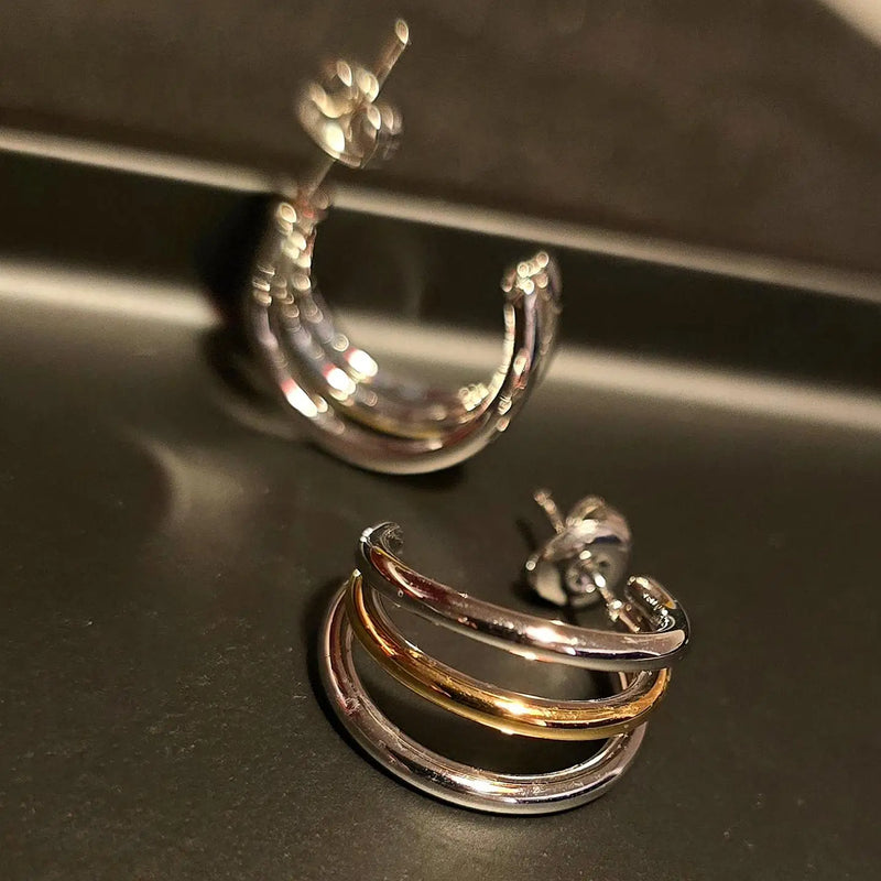 Henriette Triple-Band Hoop Earrings, two colourways on a metallic surface