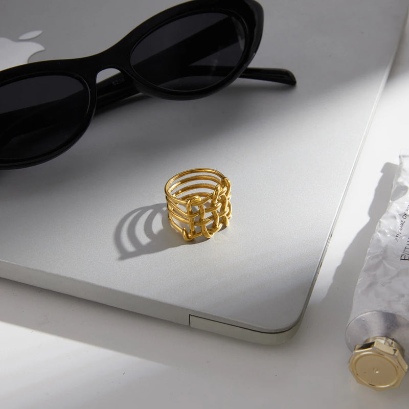 Basketweave ring on a laptop beside black sunglasses