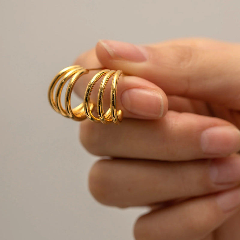 Henriette Triple-Band Hoop Earrings held between finger and thumb
