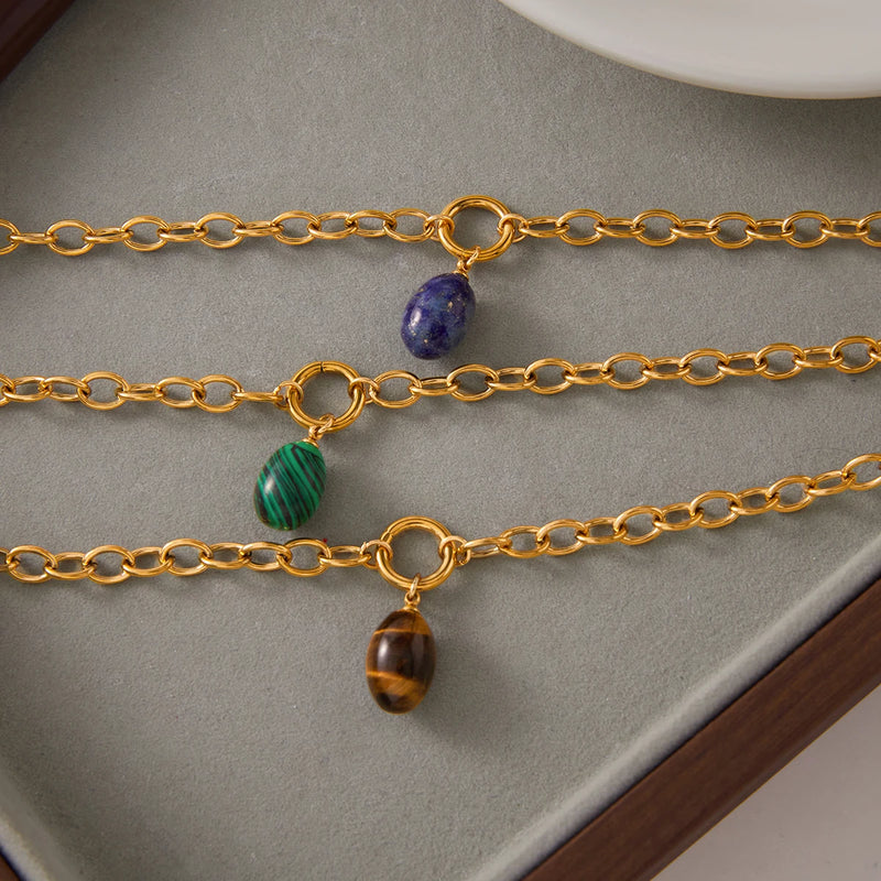 Three chains with blue, green and brown stone drops laid side by side