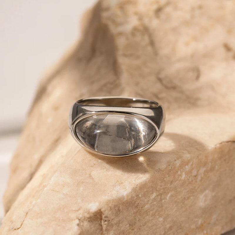 Silver-tone domed cabochon ring resting on pale stone