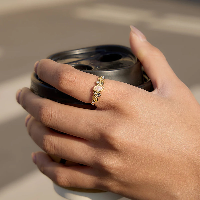 Crystal-set open ring worn on a hand holding a cup lid