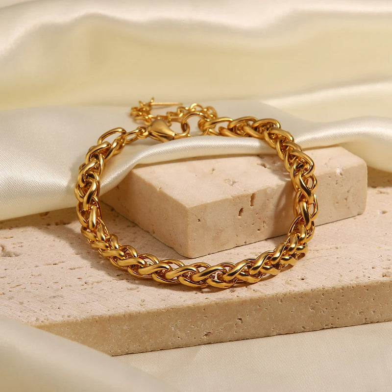 Wheat chain bracelet draped over a pale stone block