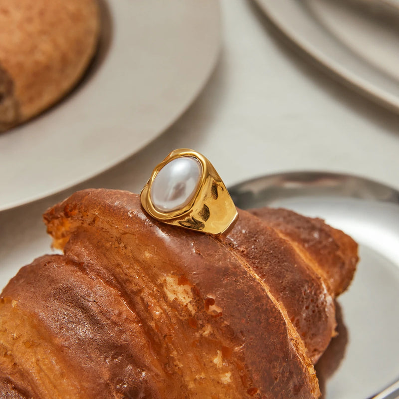 Signet ring resting on a croissant on a pale plate