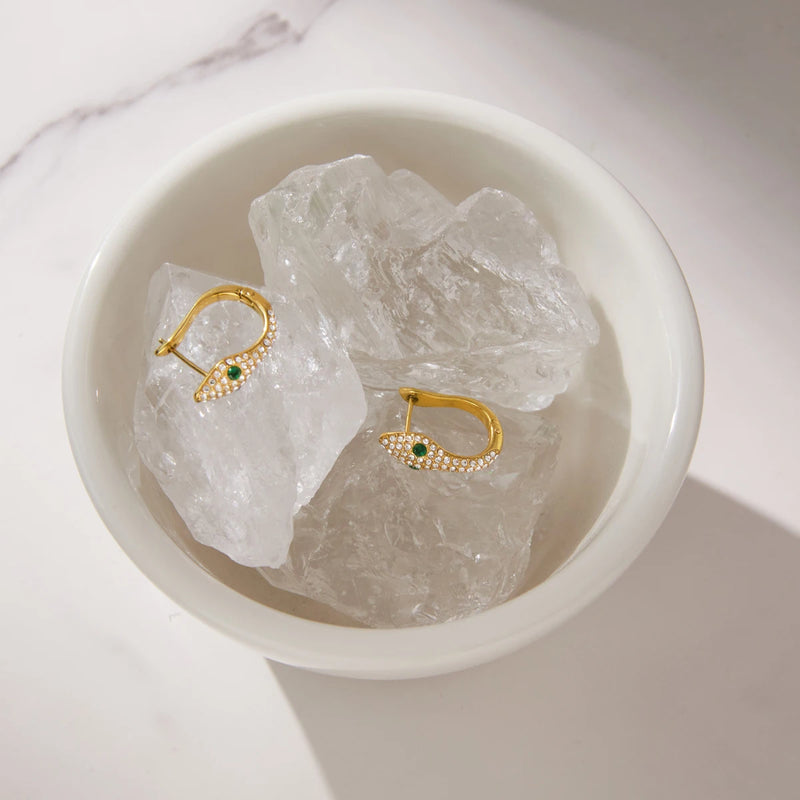 Pair of crystal-set hoops in a white bowl with clear stones