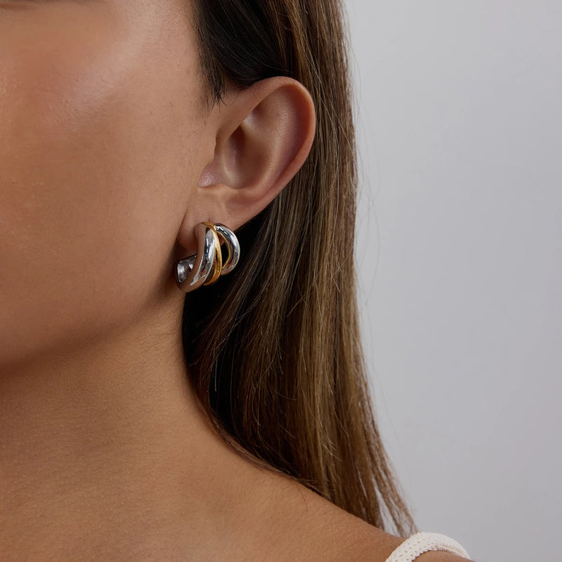 Crossover hoop earring worn on the ear, hair tucked back