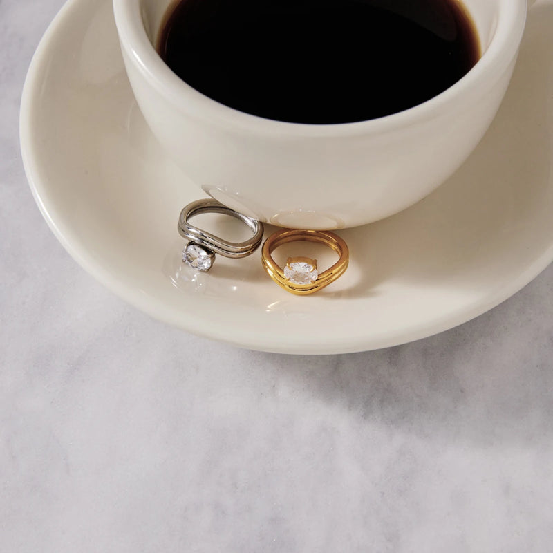 Two wave rings on a saucer beside a cup of black coffee