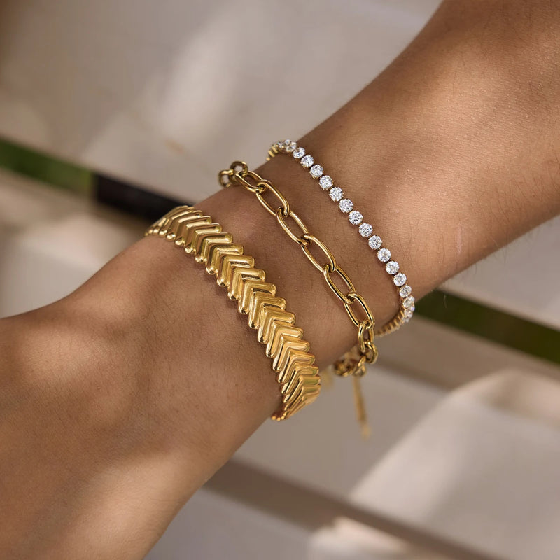 Chevron cuff worn stacked with a chain and a crystal bracelet