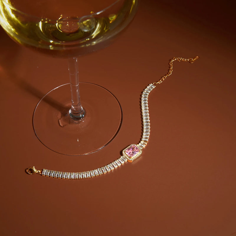 Cecile Crystal Tennis and Halo Heart Bracelet photographed beside a glass