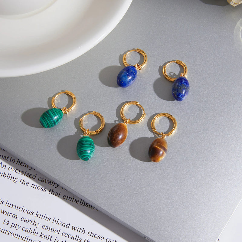 Blue, green and brown stone drop hoops laid on an open book