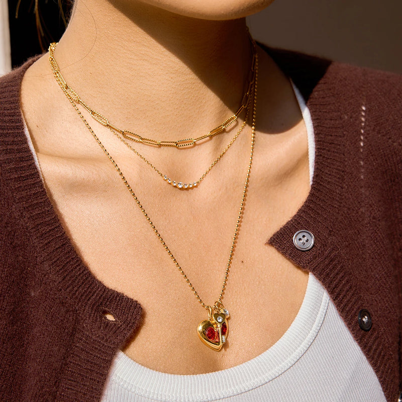 Heart and key charm necklace layered with a second chain