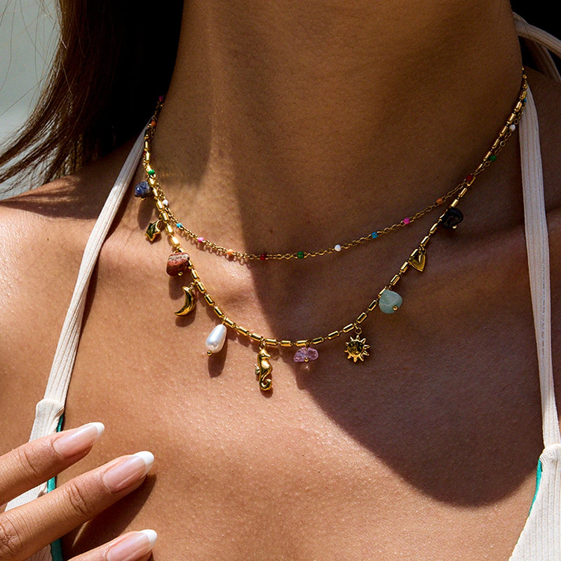 Close view of the layered charm chains worn on the chest