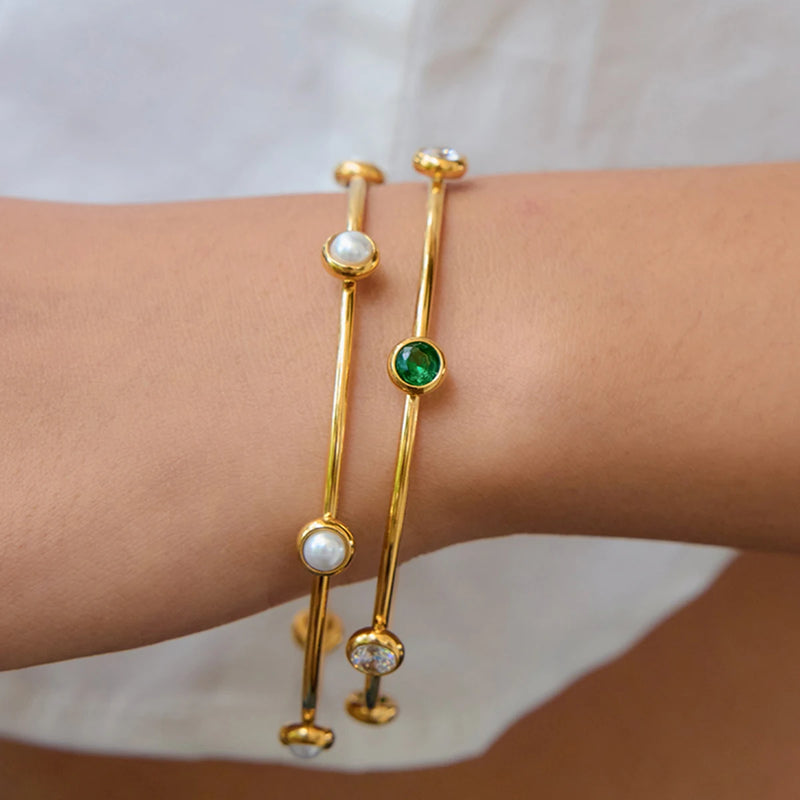 Two stone station bangles worn on a wrist