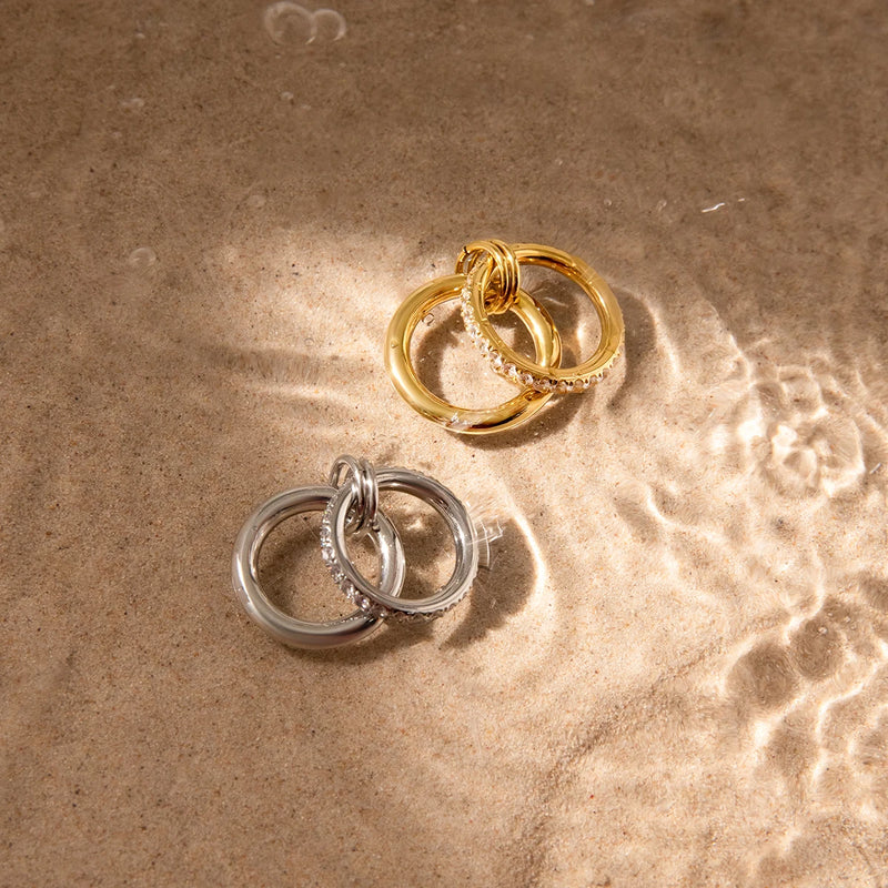 Louise Interlocking Double Band Ring, both colourways photographed on wet sand