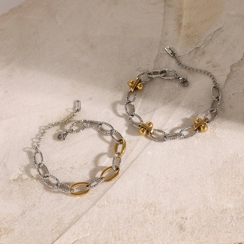 Silver-tone chain bracelets with gold-tone links, laid flat