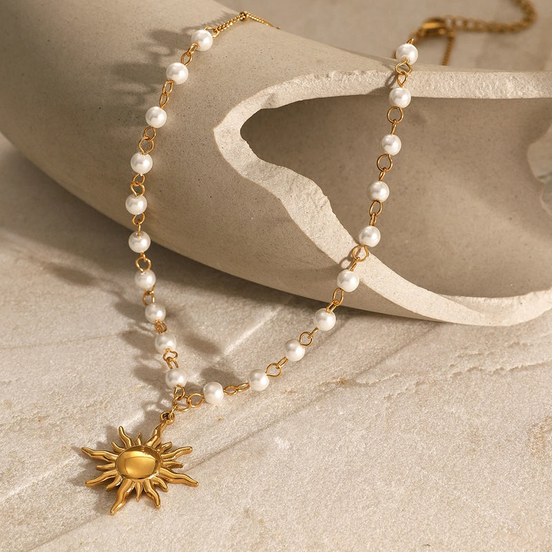 Pearl necklace with a sun pendant draped over a ceramic form