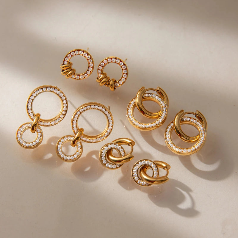Group of circle link earrings laid on a cream surface