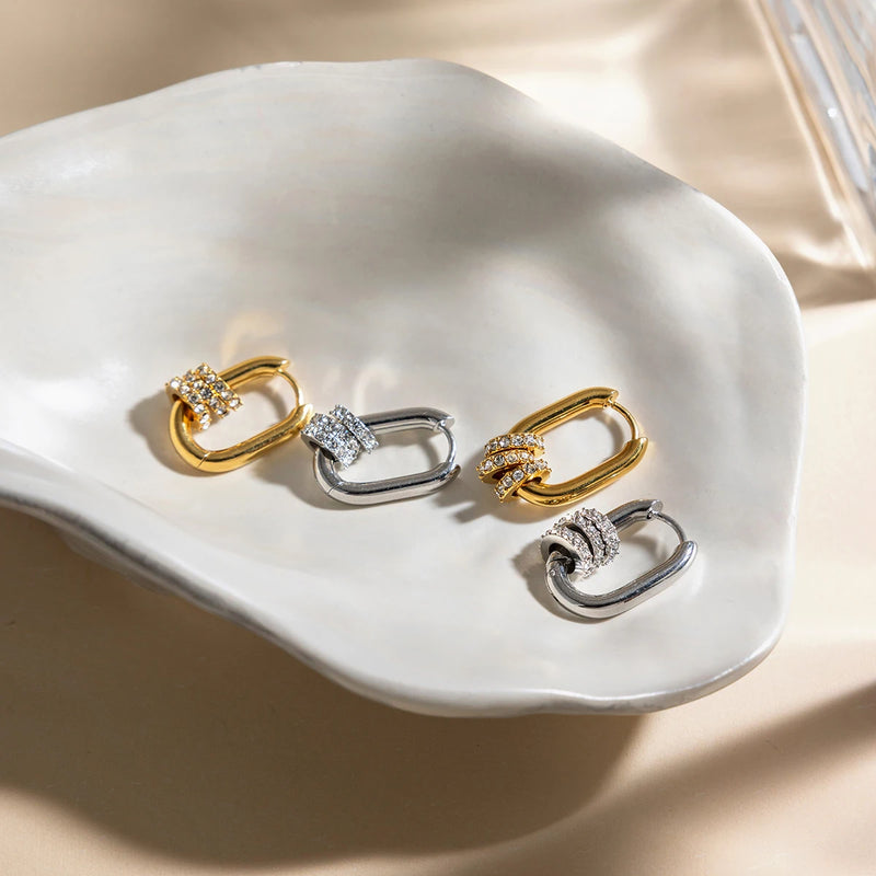 Gold and silver-tone oval hoops in a white ceramic dish
