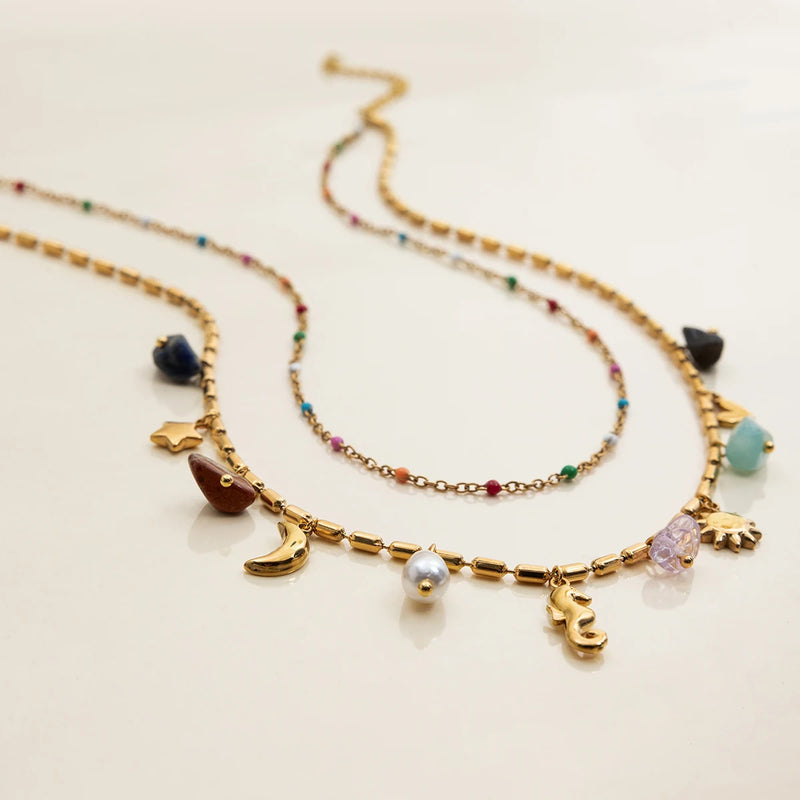 Two beaded charm necklaces with a seahorse charm on cream
