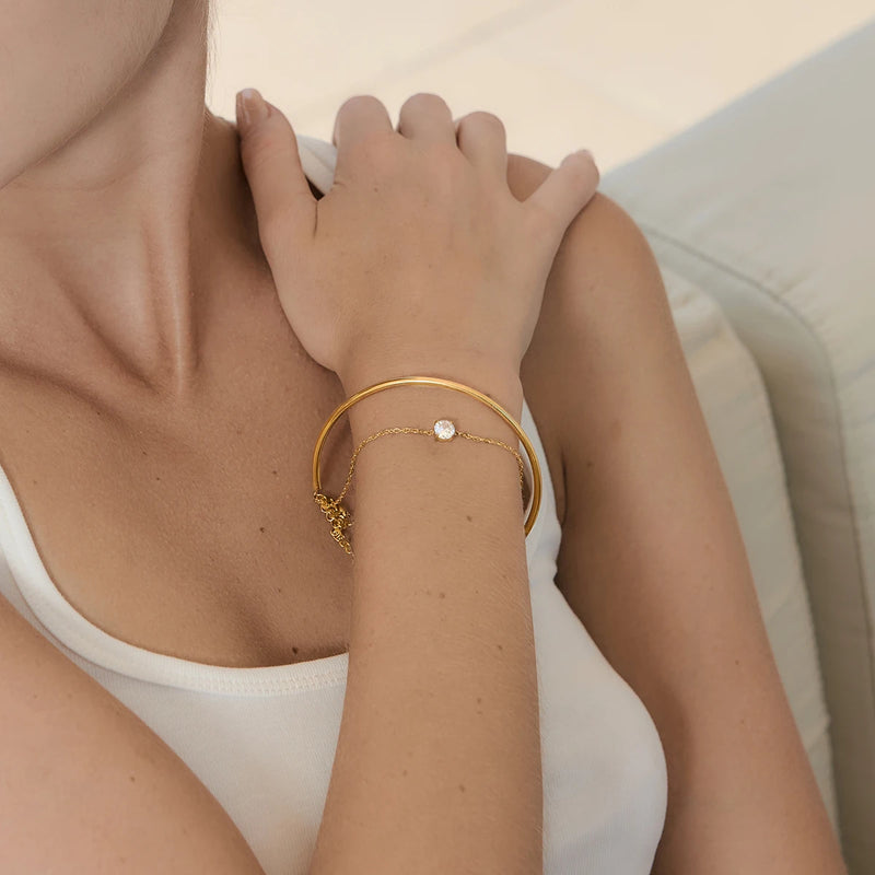 Bangle worn on a wrist, hands crossed at the shoulder