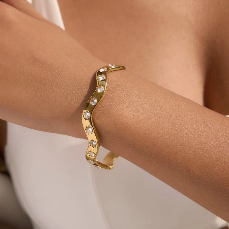 Crystal-set wave bangle worn on a bare arm