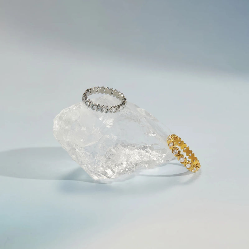 Two crystal eternity rings arranged around a rough clear stone