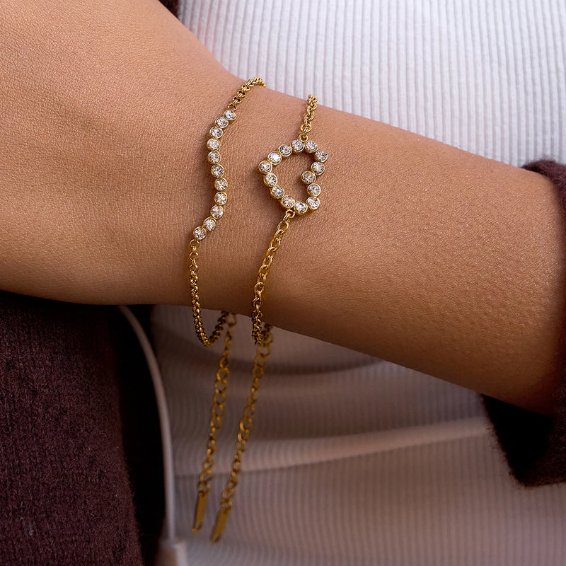 Crystal heart and crystal-set chain bracelets worn on a wrist