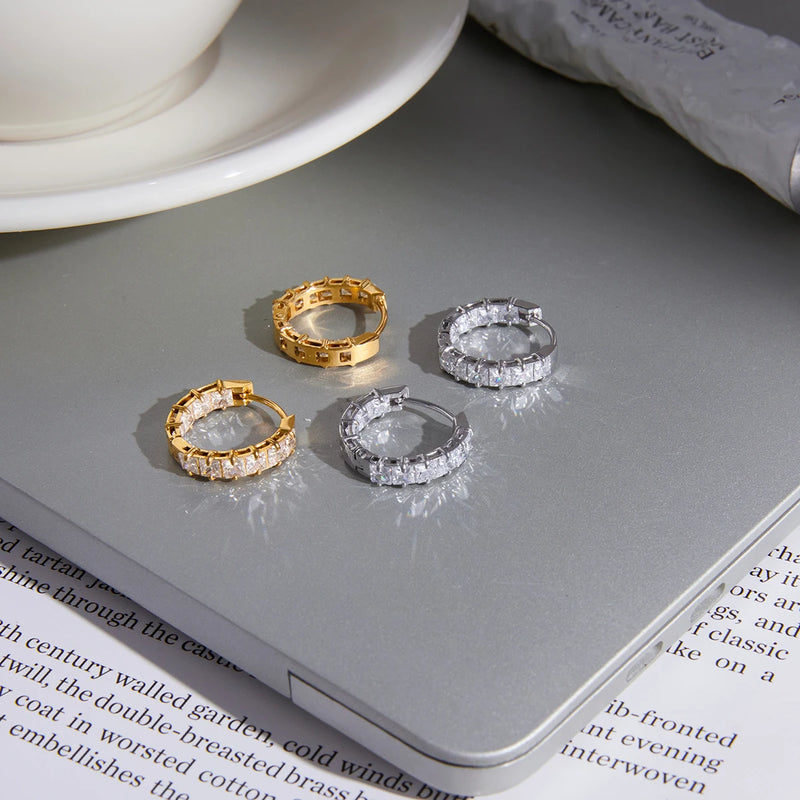 Gold-tone and silver-tone crystal huggie hoops on a laptop