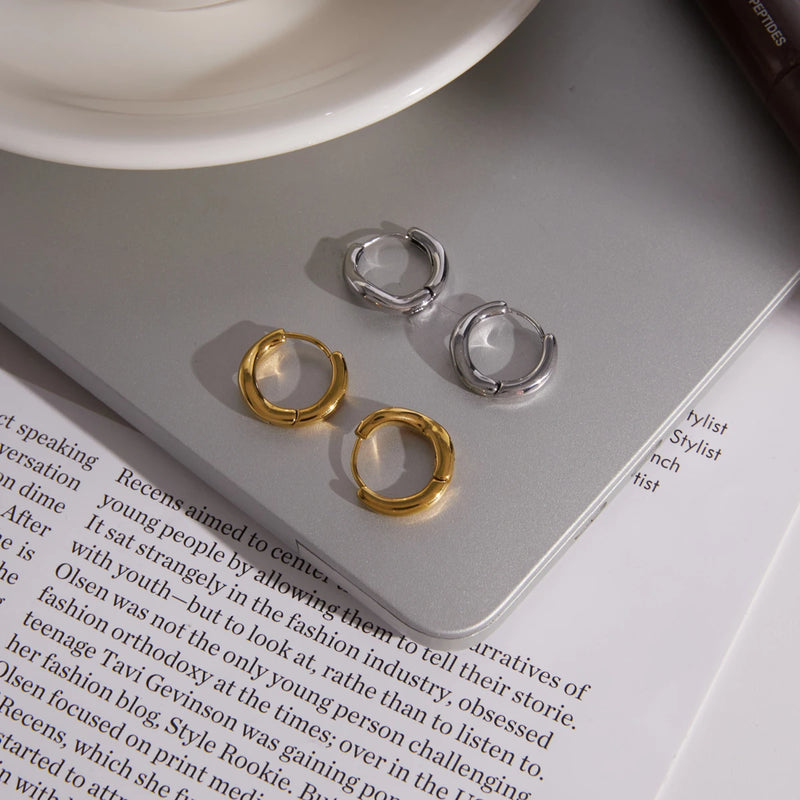 Gold-tone and silver-tone sculpted hoops on an open magazine