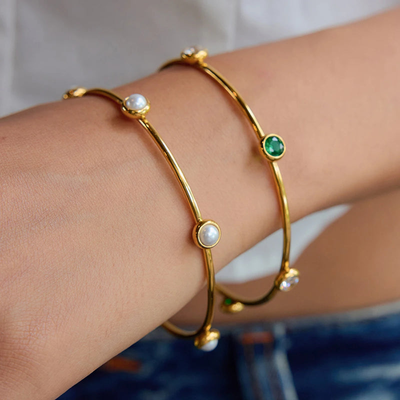 Slim bangle with green and pearl stations worn on a wrist