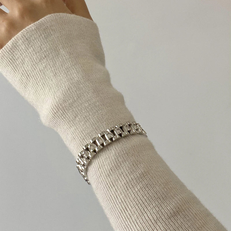 Watch-link bracelet worn on a wrist, arm turned away