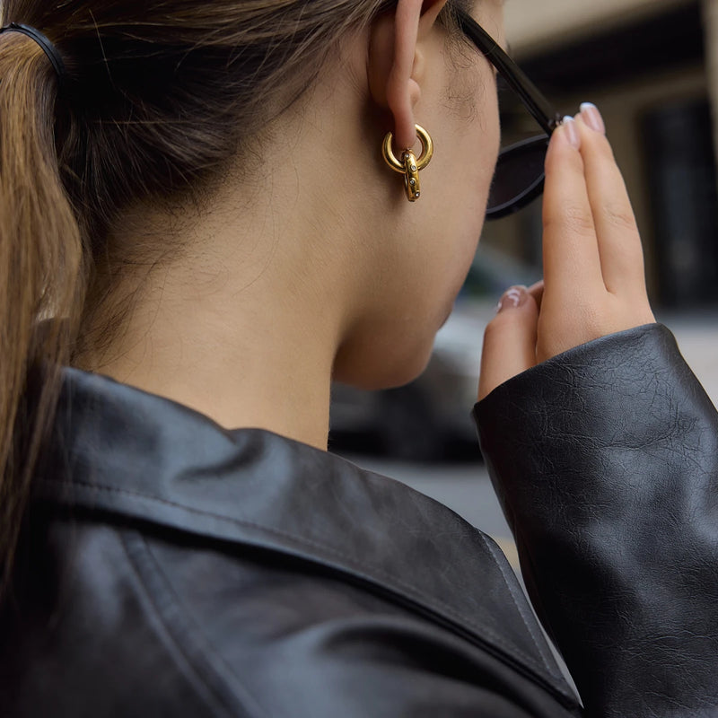 Double circle earrings worn with sunglasses and a leather jacket